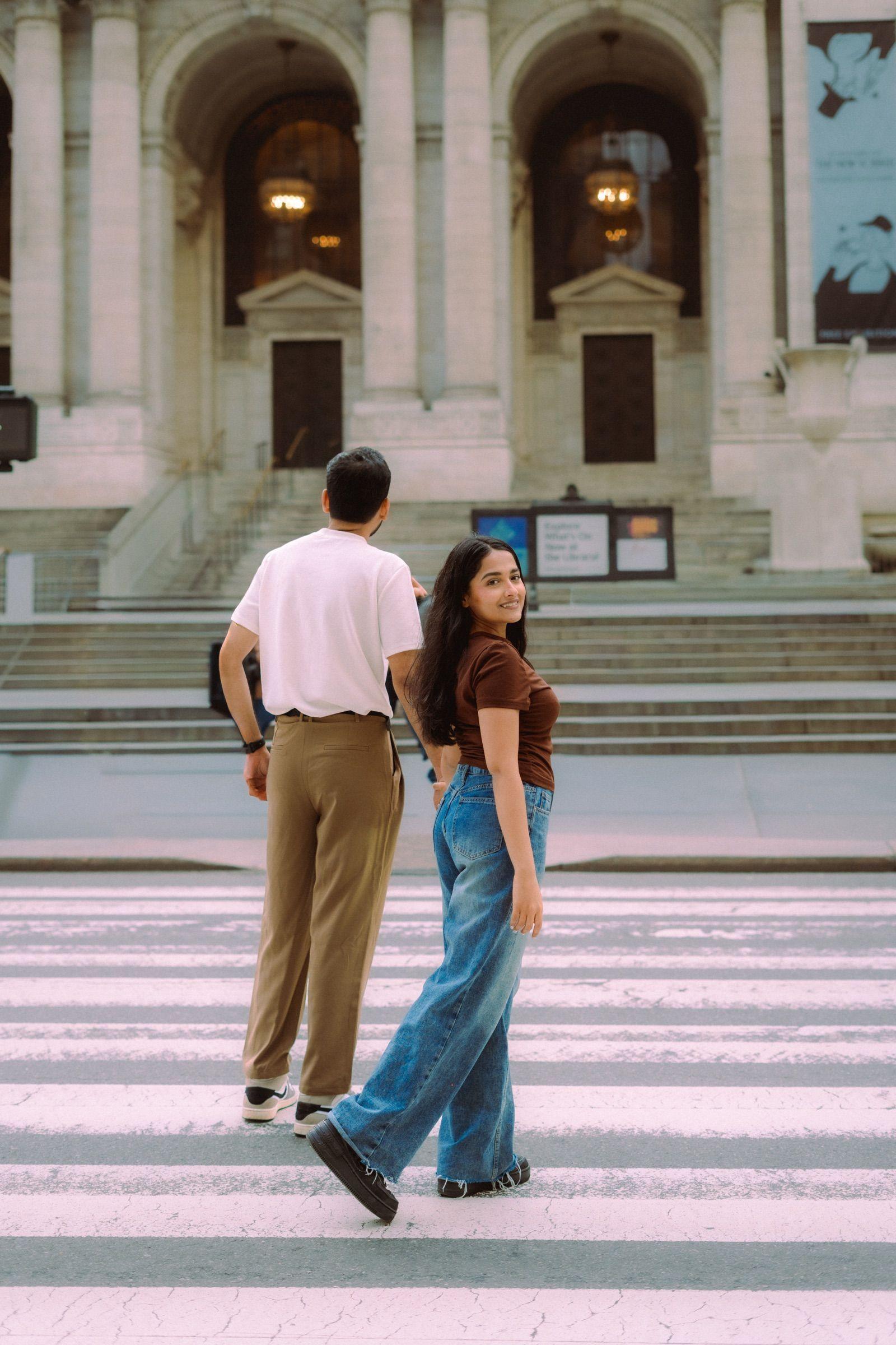 Wide shot of a couple walking hand-in-hand through Central Park.